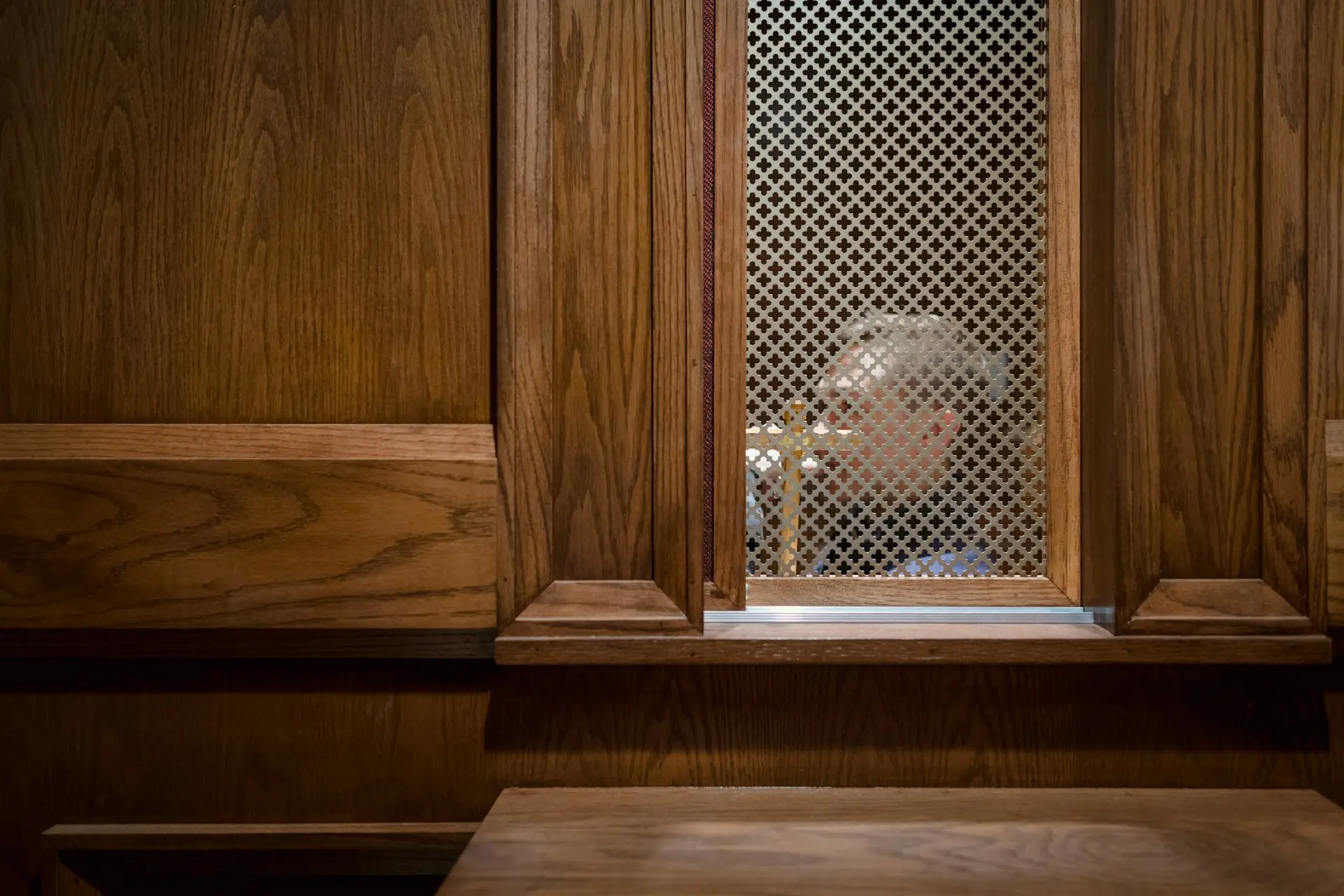 a man looking through a window in a wooden building